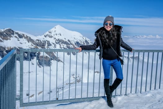 Young Woman Tourist at the Schilthorn in Switzerland with a magnificent panoramic view of the Swiss Skyline. 