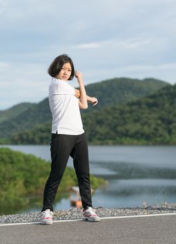 Fitness and lifestyle concept - Young asian woman short hair doing exercising outdoor
