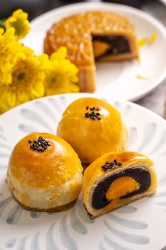 Tasty baked egg yolk pastry moon cake for Mid-Autumn Festival on bright cement table background. Chinese traditional food concept, close up, copy space.