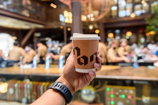 Bangkok, Thailand - 16 September, 2020:  The man hand show a cup of hot coffee of NANA Hunter Coffee Roasters 

coffee brand