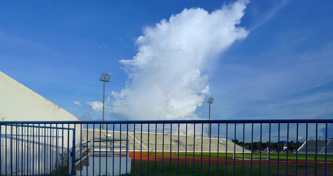 The stadium's sky has pillars, spotlights, and a rainbow.