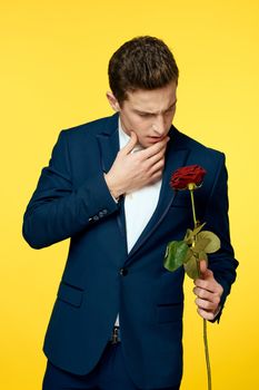 Gentlemen in classic suit on yellow background and red rose romance cropped view model portrait. High quality photo