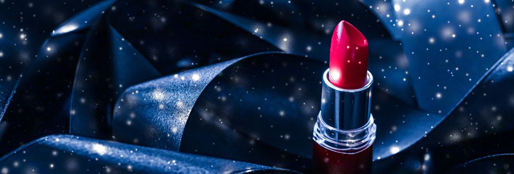 Red lipstick on blue silk and shiny glitter background, luxury make-up and beauty cosmetics