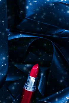 Red lipstick on blue silk and shiny glitter background, luxury make-up and beauty cosmetics