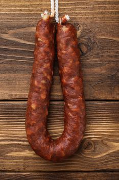 Spicy chorizo bratwurst sausage on light wooden background, flat lay.