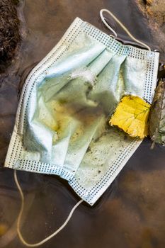 Surgical masks in the nature. Hanging in a lake. Corona virus pollution. Leherheide, Bremerhaven.