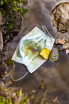 Surgical masks in the nature. Hanging in a lake. Corona virus pollution. Leherheide, Bremerhaven.