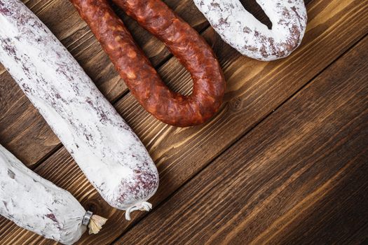 Traditional spanish smoked sausages meat hanging on wood table with space for text.