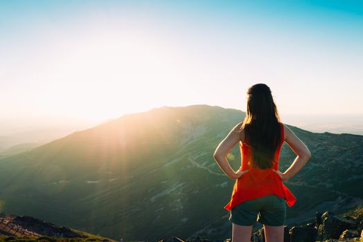 woman watching a sunset in the mountains.