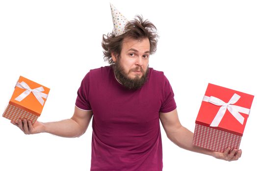 Crazy bearded Man with funny Haircut in birthday cap, isolated on white background. Confused guy holding gift boxes. Holidays concept.