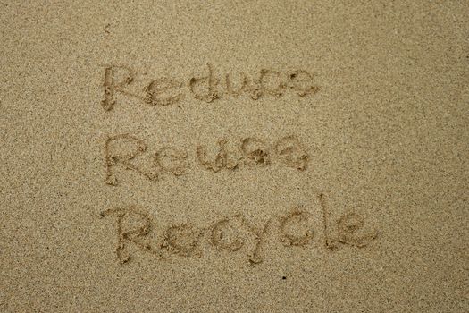 reduce reuse recycle concept drawn on sand, sustainability.
