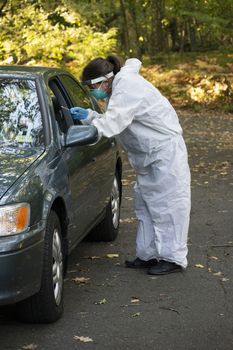 Covid19 Coronavirus healthcare worker performing virus testing outdoors for pandemic