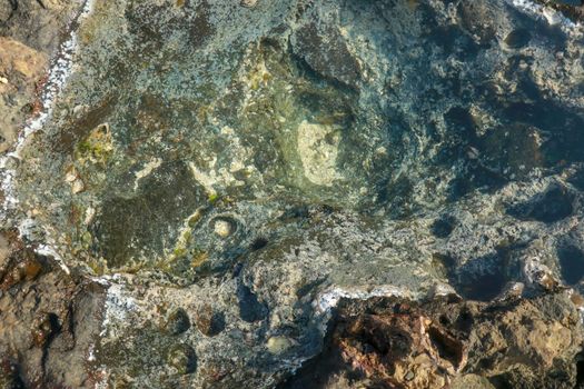 Water puddle and rock texture at the ocean coast.