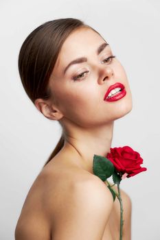Woman with bare shoulders With a rose in his hands red lips front view
