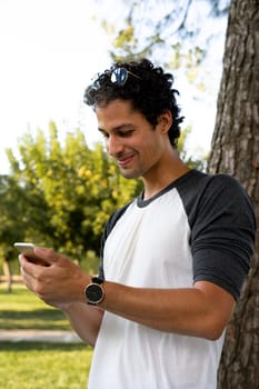 Portrait of handsome young man using his mobile phone outside