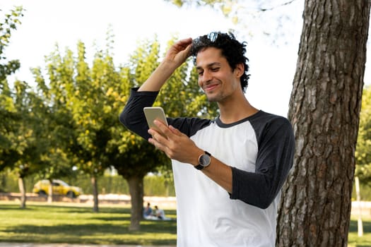 Portrait of handsome young man using his mobile phone outside