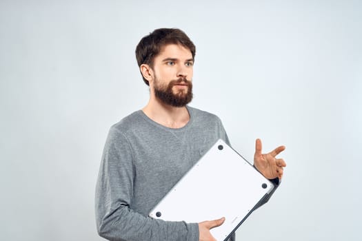 Emotional man holding a laptop success modern style work light background. High quality photo