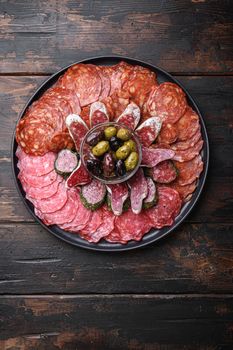 Antipasto platter cold meat with chorizo, fuet,salami, salchichon and longaniza on dark wooden background.