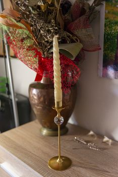 candlestick with crystal and candle in vase background with dry flowers