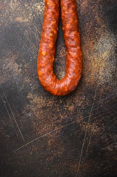 Traditional chorizo salami sausage on dark background, flat lay with copy space.