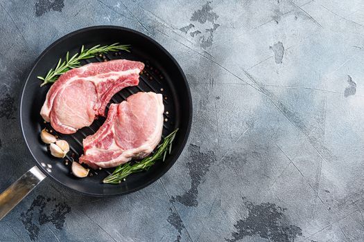 Pork Chops with spices for grill cast iron pan top view space for text.