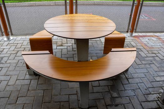 Round light brown table, outdoor roadside cafe on an autumn day.