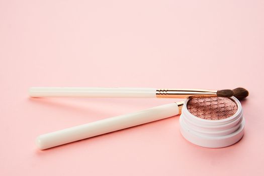 makeup brushes and eyeshadow professional cosmetics on pink background. High quality photo