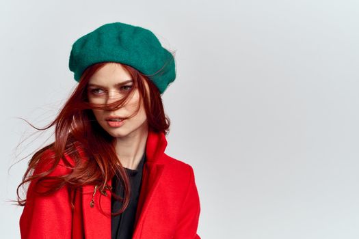 Woman in red coat and in green hat on isolated background cropped model with Copy Space emotions. High quality photo