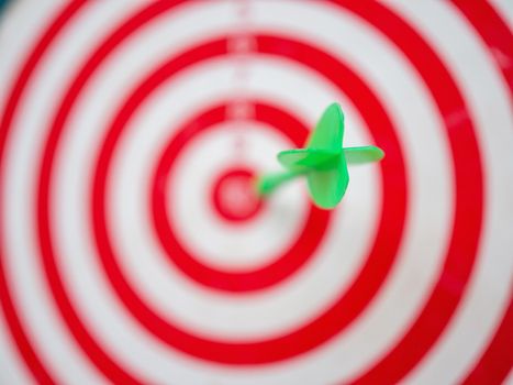 Green arrow strikes center of goal on blurred background - Successful business goal idea.