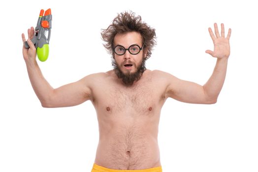 Crazy bearded Man with funny Haircut in eye Glasses, ready for fun at sunny beach. Happy and silly tourist, isolated on white background. Cheerful naked man holding Water Gun.