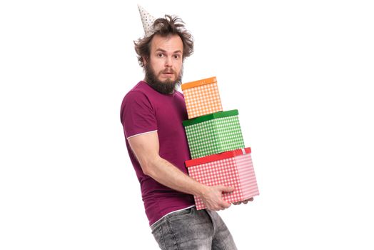 Crazy bearded Man with funny Haircut in birthday cap, isolated on white background. Surprised guy holding many gift boxes. Holidays concept.