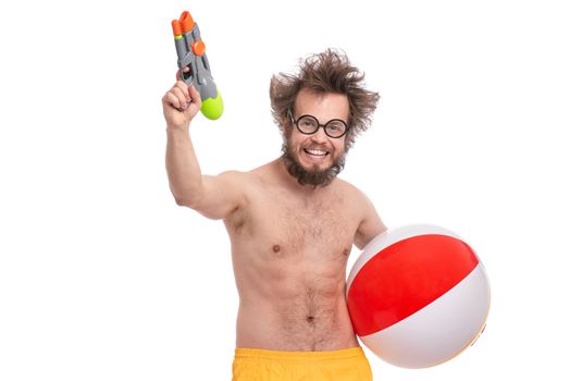 Crazy bearded Man with funny Haircut in eye Glasses, ready for fun at sunny beach. Happy and silly tourist, isolated on white background. Cheerful naked man holding Water Gun and Sea Ball.