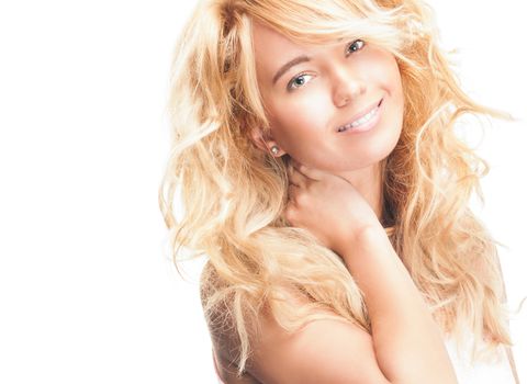 Beautiful and happy young woman standing isolated on white background. Looking into the camera and smiling, her hand on her neck.