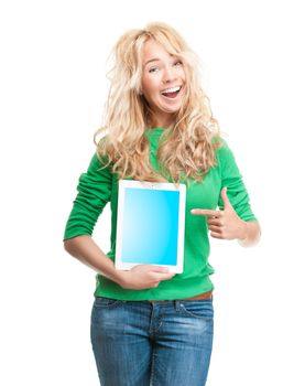 Beautiful and happy young woman standing isolated on white background. Smiling and looking into the camera. Casual style, tablet computer in her hand, pointing to the screen.