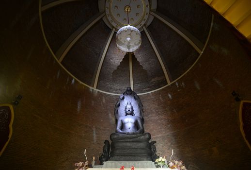 Buddha in Meditation under a Seven-Headed Naga under the the royal nine tiered umbrella  inside Wat Ratchabophit, Bangkok, Thailand