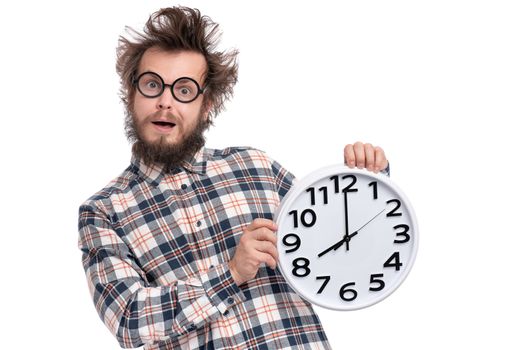 Crazy bearded Man in plaid shirt with funny Haircut in eye Glasses holding Big Clock, isolated on white background. Time concept.