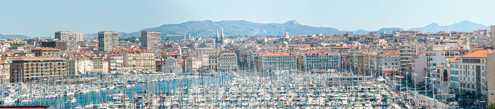 City view of Marseille, France. Panorama of Marseilles with great number of yachts in foreground and rocky hills in background. Densely populated city with lots of historical places.