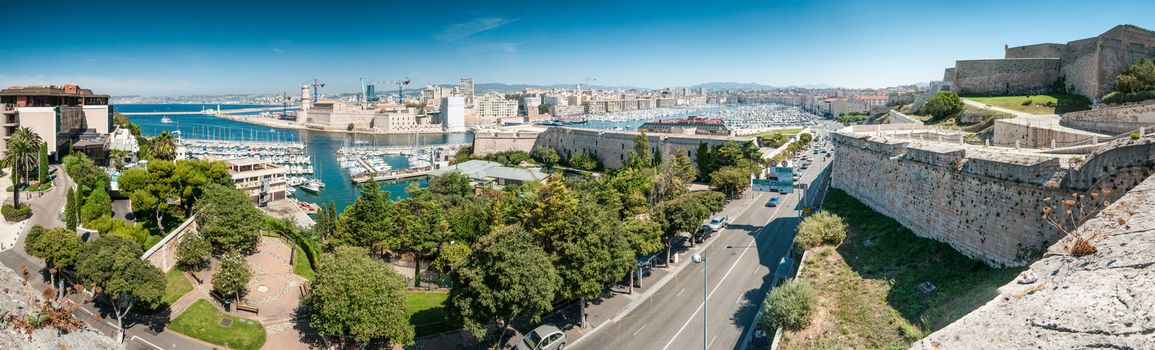 Scenic view of Marseille from height, France. Panorama of Marseilles with its harbor and variety of yachts, city road, old and modern buildings. Densely populated city with lots of historical places.