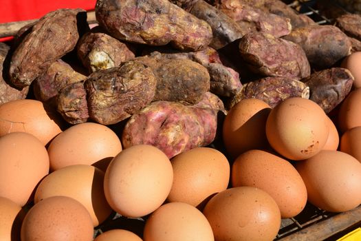 Grilled Eggs and Burning yam or Sweet Potato on stove grille.