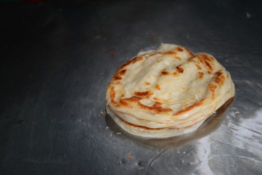 Soft focus of Roti Canai or Roti thresh flour by roti maker with oil. Indian traditional street food.Hand making roti