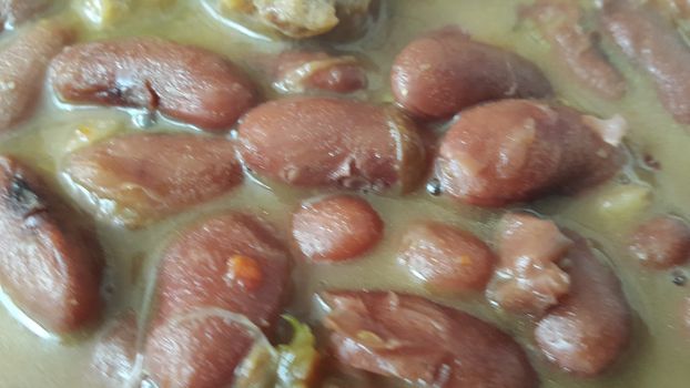 Kidney beans dish:  Closeup view of cooked red kidney beans dish. Dark red useful beans dish background.