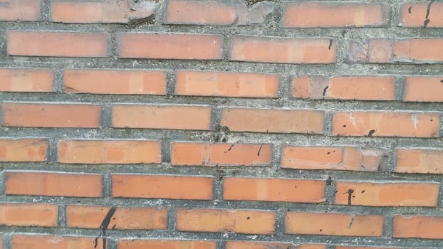 Closeup texture of red brick wall. A background of a weathered old exterior brick wall in the sunshine.