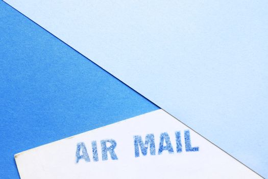 Blue air mail stamp on a white postcard ,blue paper background , 