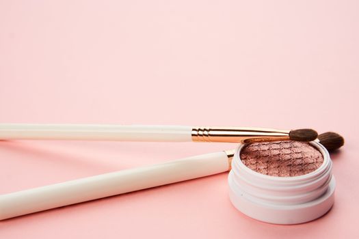 makeup brushes and eyeshadow professional cosmetics on pink background. High quality photo