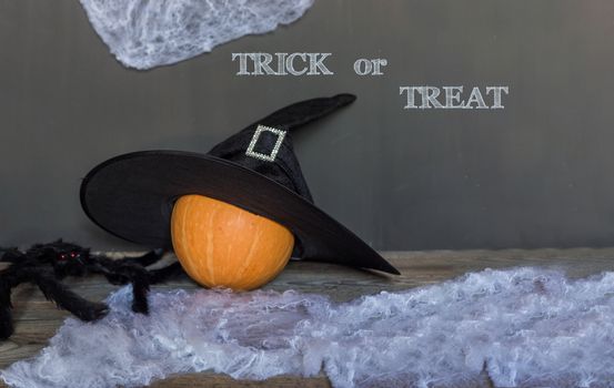Trick or treat greeting text over dark wooden and Blackboard background