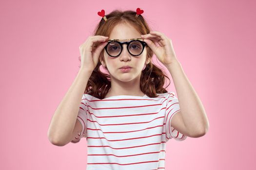 Cute girl sunglasses striped t-shirt lifestyle fun style pink background. High quality photo