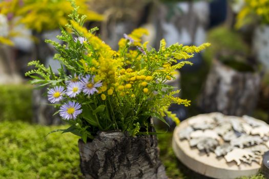 Bouquet of wildflowers in a bark vase, eco-friendly interior decoration concept