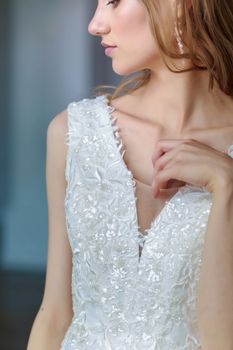 Close-up cropped portrait of Bride in white wedding dress with pensive look down