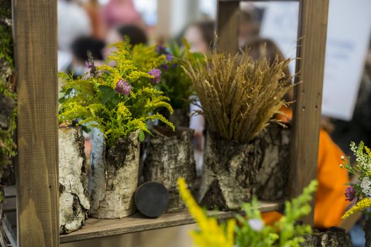 Bouquet of wildflowers in a bark vase, eco-friendly interior decoration concept
