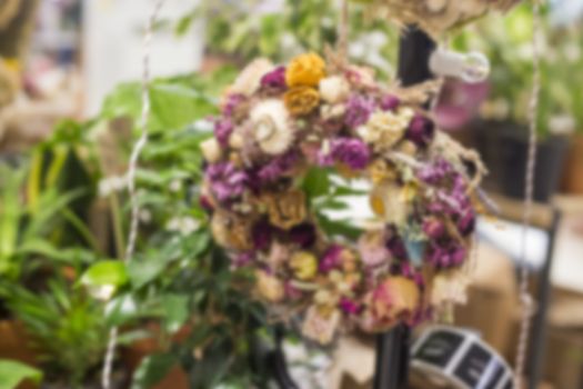 Out of focus blurred floristic background of dried flowers wreath on the wall